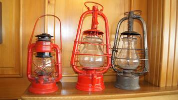 Trois lanternes anciennes sont posées sur une étagère en bois.