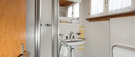 A bathroom with a shower, sink, and toilet.