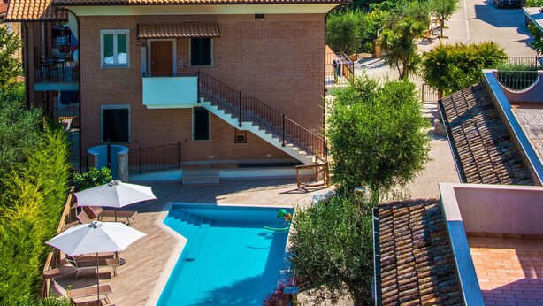 Un bâtiment à deux étages doté d’une piscine, d’un clocher et offrant une vue sur la mer.