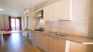 Une cuisine moderne avec des meubles en bois, un évier en acier inoxydable et une cuisinière à gaz.