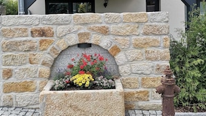 A building with a stone facade, a balcony with flower boxes, and a fire hydrant.