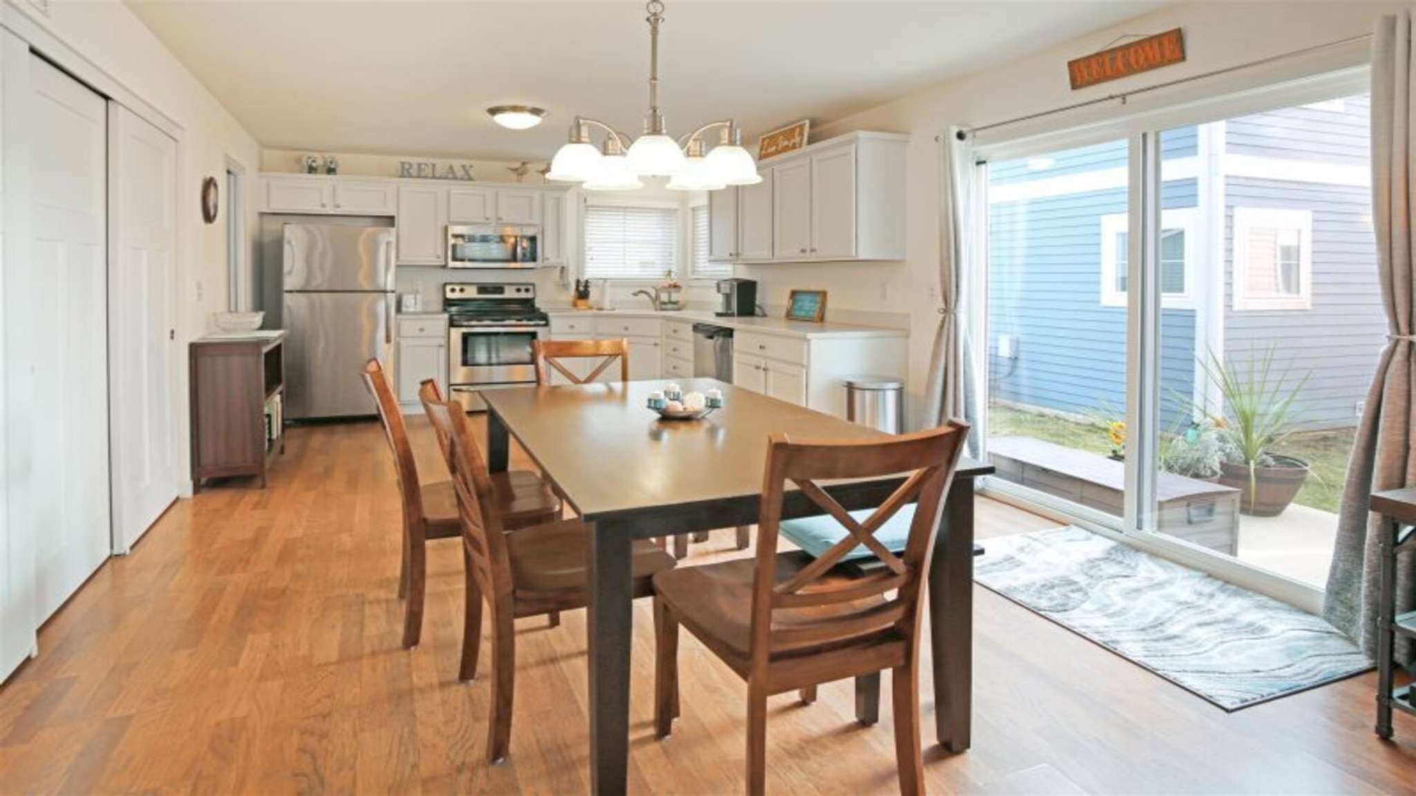 A kitchen with a dining table, chairs, and a view of the outside.