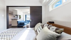 A modern hotel room with a bed, a sofa, and a view of the living area. - Stardust (Sapporo)
