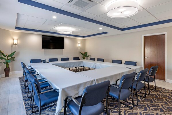 A conference room with a long table, chairs, a flat-screen TV, and wall-mounted lights. - Comfort Suites St. Louis - Sunset Hills (St. Louis)