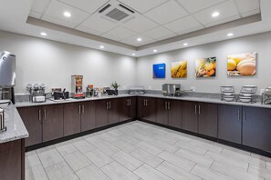 A modern kitchen with granite countertops, dark cabinetry, and a coffee station. - Comfort Suites St. Louis - Sunset Hills (St. Louis)