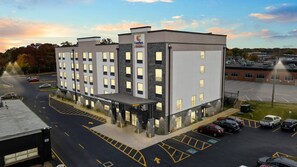 A multi-story hotel with a modern design, featuring a covered entrance and a parking lot with marked spaces. - Comfort Suites St. Louis - Sunset Hills (St. Louis)