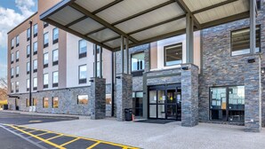 A modern building with a stone facade, large windows, and a covered entrance area. - Comfort Suites St. Louis - Sunset Hills (St. Louis)