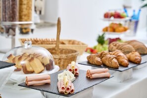 A buffet with various pastries and sandwiches.