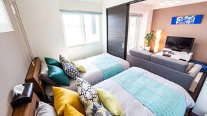 A hotel room with two beds, a TV, a desk, and a window. - Edifice (Sapporo)