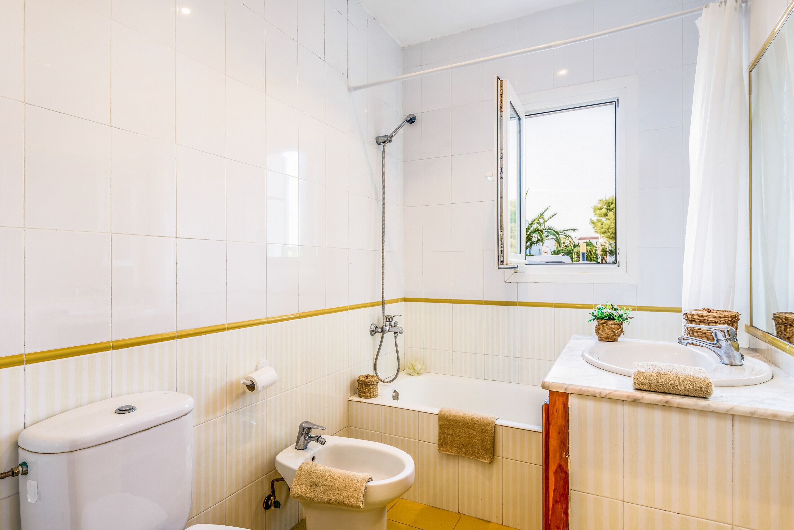 Un baño con inodoro, bidé, bañera y lavamanos.