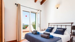 Une chambre à coucher avec un lit, des oreillers et une vue sur l’extérieur.