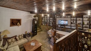 A rustic interior with a wooden ceiling, stone flooring, a wooden dining table, and a television on the wall. - Rent-a-villa with outdoor jacuzzi, BBQ, trampoline and indoor infrared sauna (Medven)