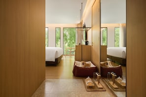 Une chambre d’hôtel moderne avec deux lits, un coin salon et un comptoir pour le petit-déjeuner.