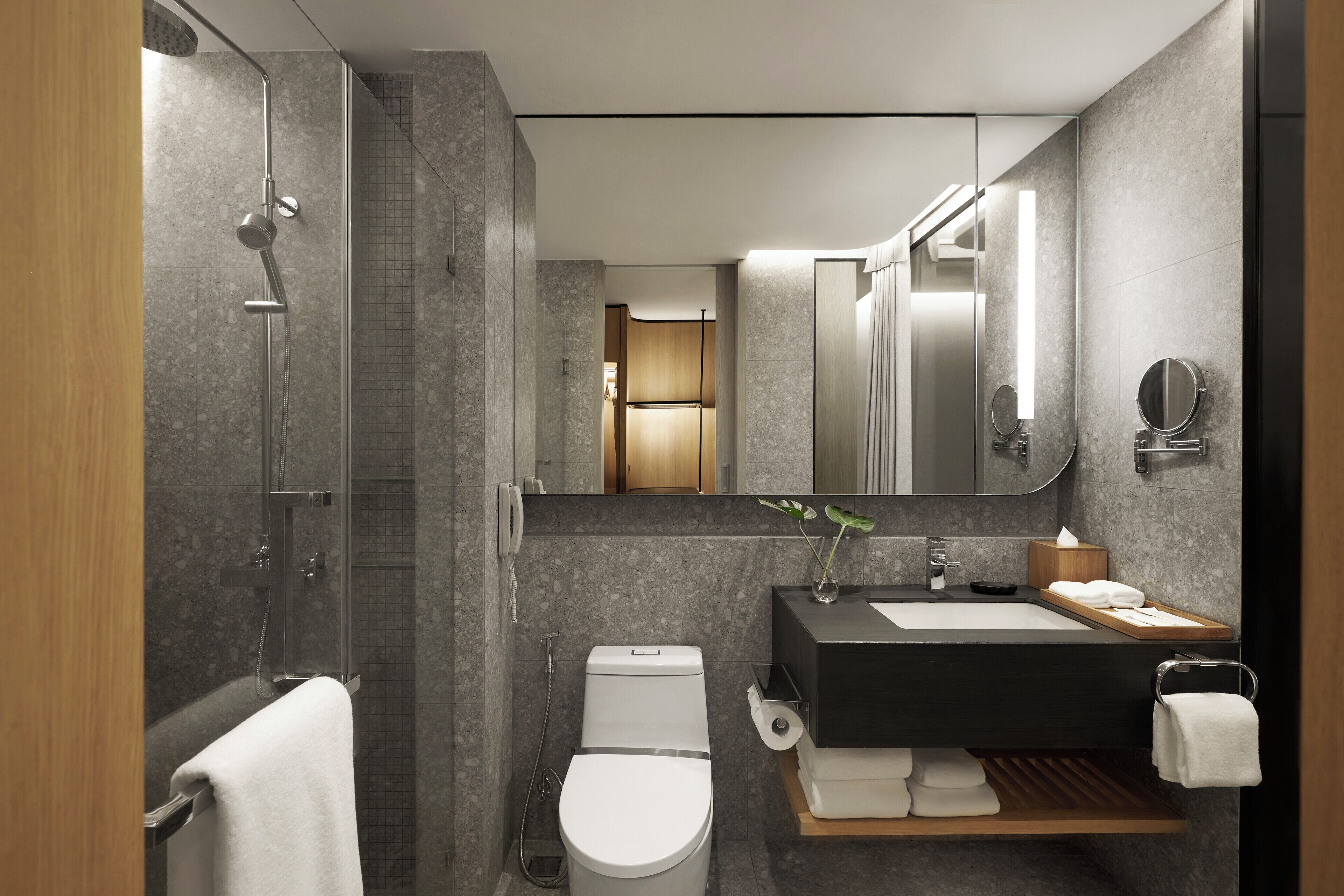 Une salle de bain moderne équipée d’une douche, de toilettes, d’un lavabo et d’un miroir.