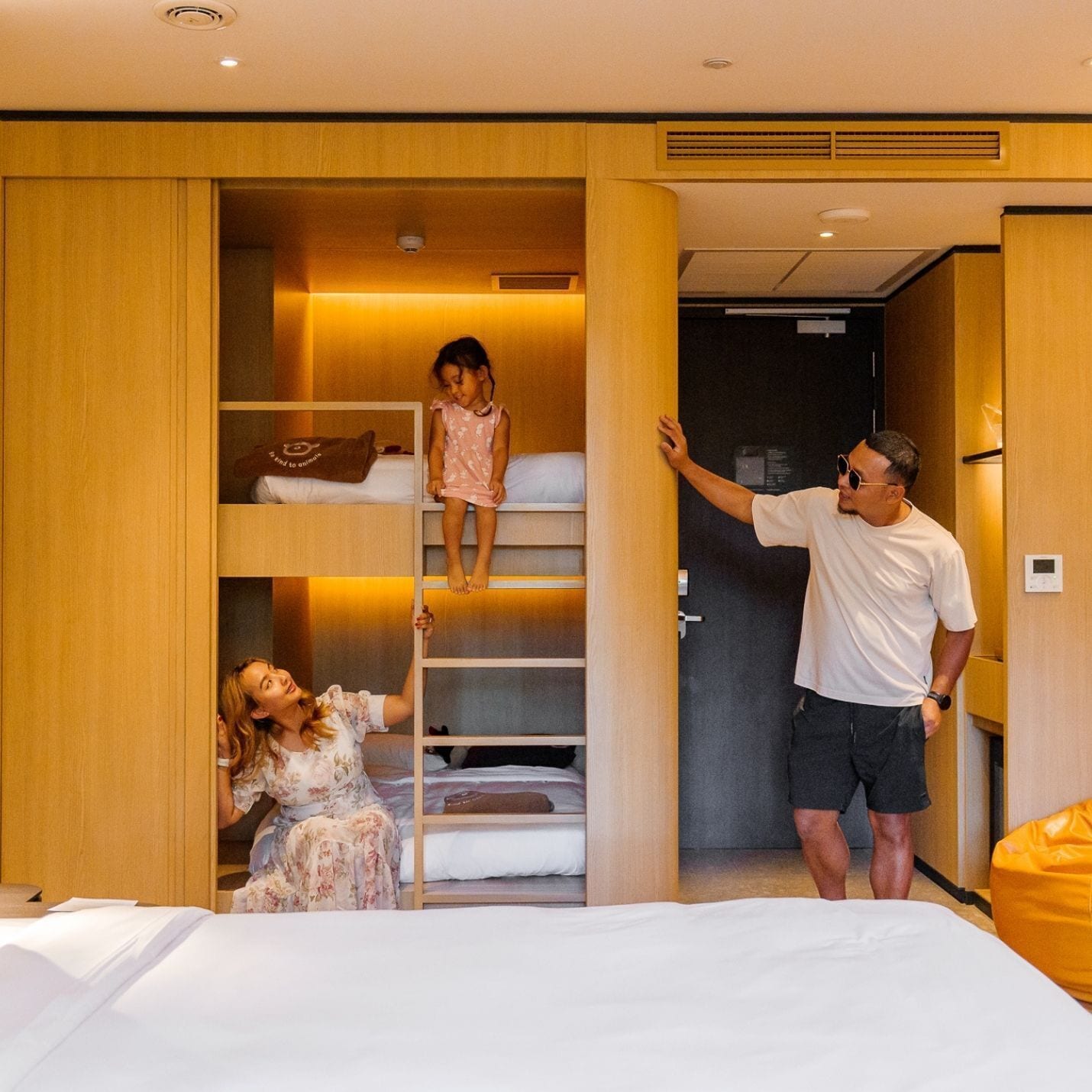 A hotel room with a built-in wardrobe, a bed, and a seating area.
