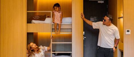 A hotel room with a built-in wardrobe, a bed, and a seating area.