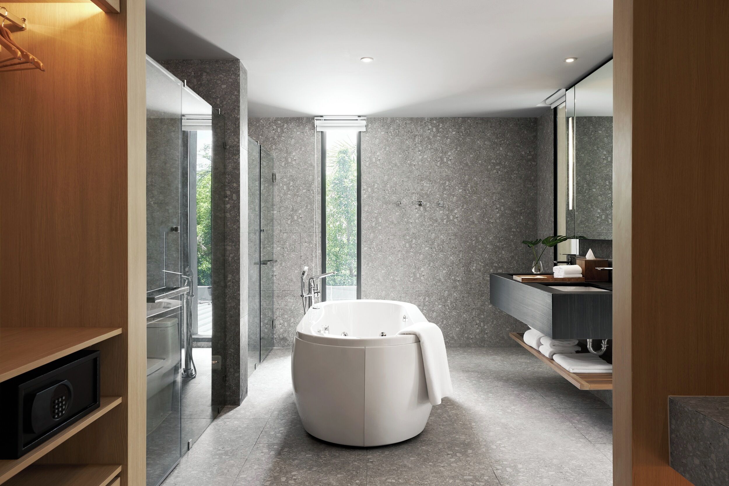A modern bathroom with a freestanding bathtub, a glass shower enclosure, and a vanity with a mirror.