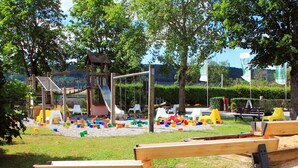 Une aire de jeux avec un toboggan, des balançoires et des structures colorées.