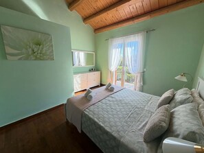 A bedroom with a bed, a dresser, a mirror, and a window with curtains. - Villa Yason Private Heated Pool Within Easy Reach Of Beaches, Tavernas & Shops. (Ionian Islands)