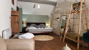 A bedroom with a wooden bed, a ladder, a mirror, and a wardrobe. - L'autre Bout de Toit (Meursault)