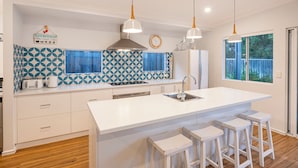 A modern kitchen with a large island, white cabinetry, and blue patterned backsplash. - Tranquility and natural setting a short distance from town and beach (Dunsborough)