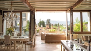 Una habitación amplia con comedor, sofá y vistas a la montaña.