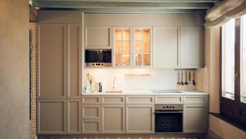 A kitchen with white cabinets, a microwave, and a stove.