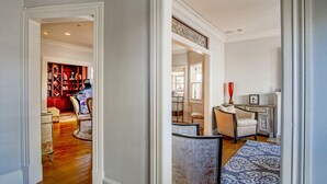 A spacious living room with a fireplace, a bookshelf, and a dining area. - Gratitude Inn - Pacific Grove House - Downtown - Close to Beach (Pacific Grove)