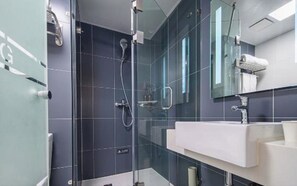 A modern bathroom with a glass shower enclosure, a white sink, and a mirror. - Hanting Hotel Hefei Guogou Plaza Branch (Hefei)