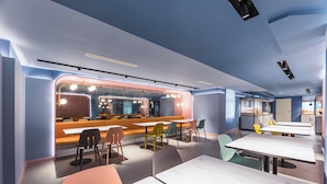 A modern restaurant interior with a bar area, seating arrangements, and a kitchen visible in the background. - Hanting Hotel Hefei Guogou Plaza Branch (Hefei)