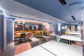 A modern restaurant interior with a bar area, seating arrangements, and a kitchen visible in the background. - Hanting Hotel Hefei Guogou Plaza Branch (Hefei)