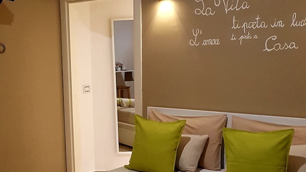 Una habitación de hotel con cama, almohadas y un adorno en la pared.