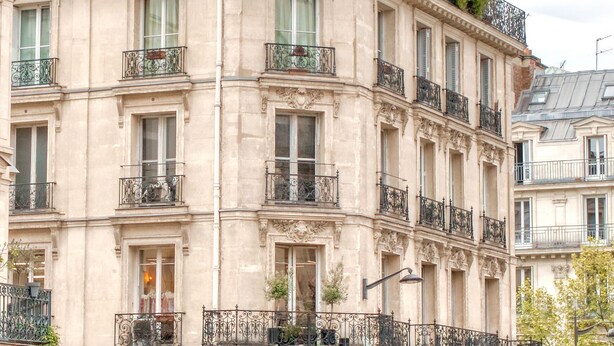 A multi-story building with ornate balconies, large windows, and a classic architectural style.