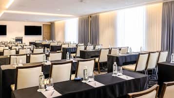 A conference room with tables set for meetings, equipped with water bottles and notepads.