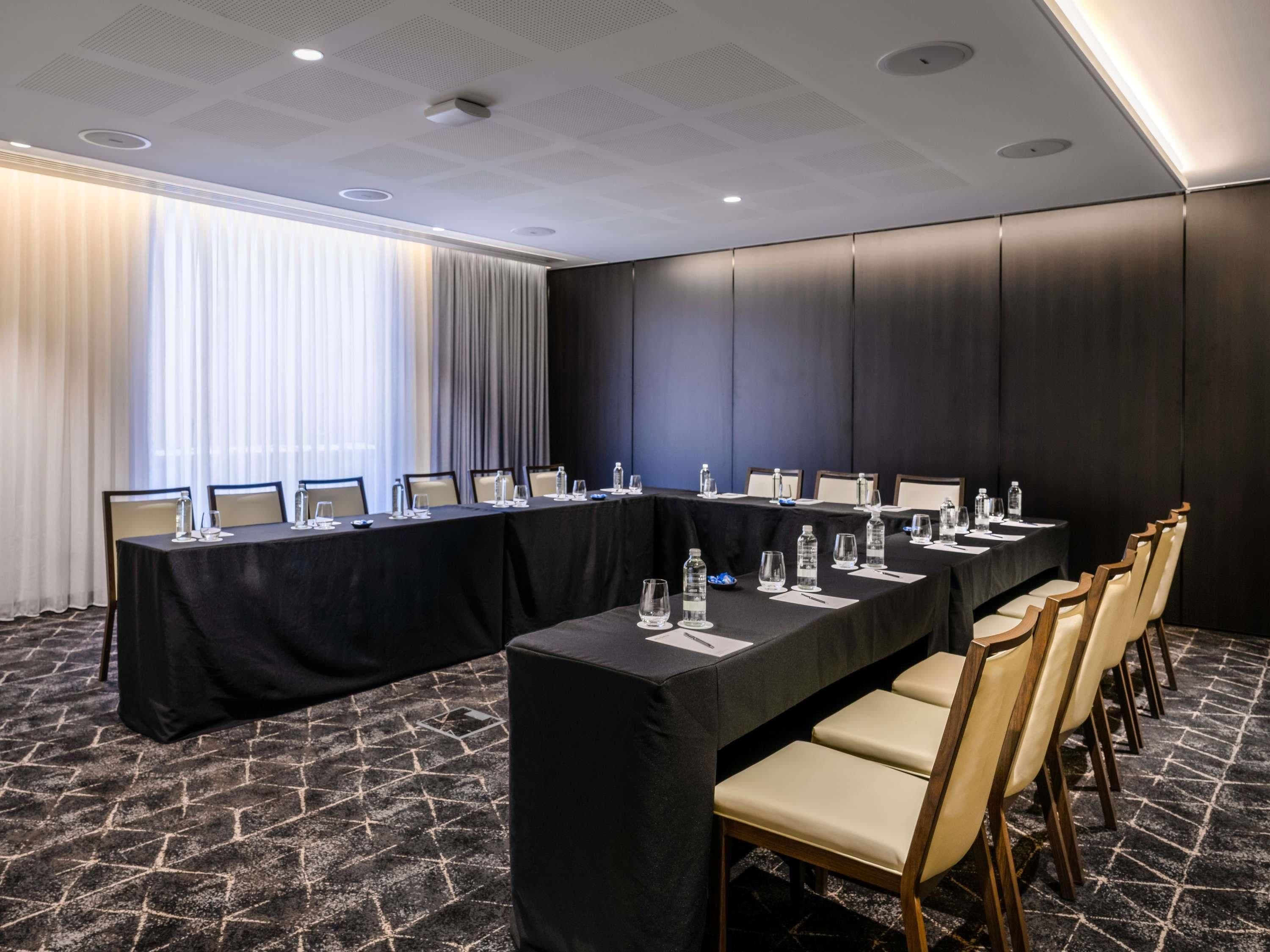 A conference room with a long table, chairs, and water bottles.
