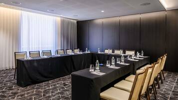 A conference room with a long table, chairs, and water bottles.