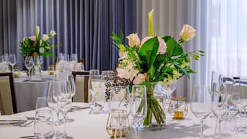 Une table dressée avec de la vaisselle transparente et un arrangement floral en guise de décoration centrale.