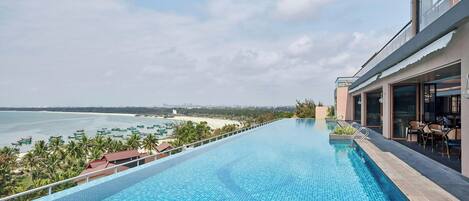 Uma piscina com vista para a praia e o oceano.