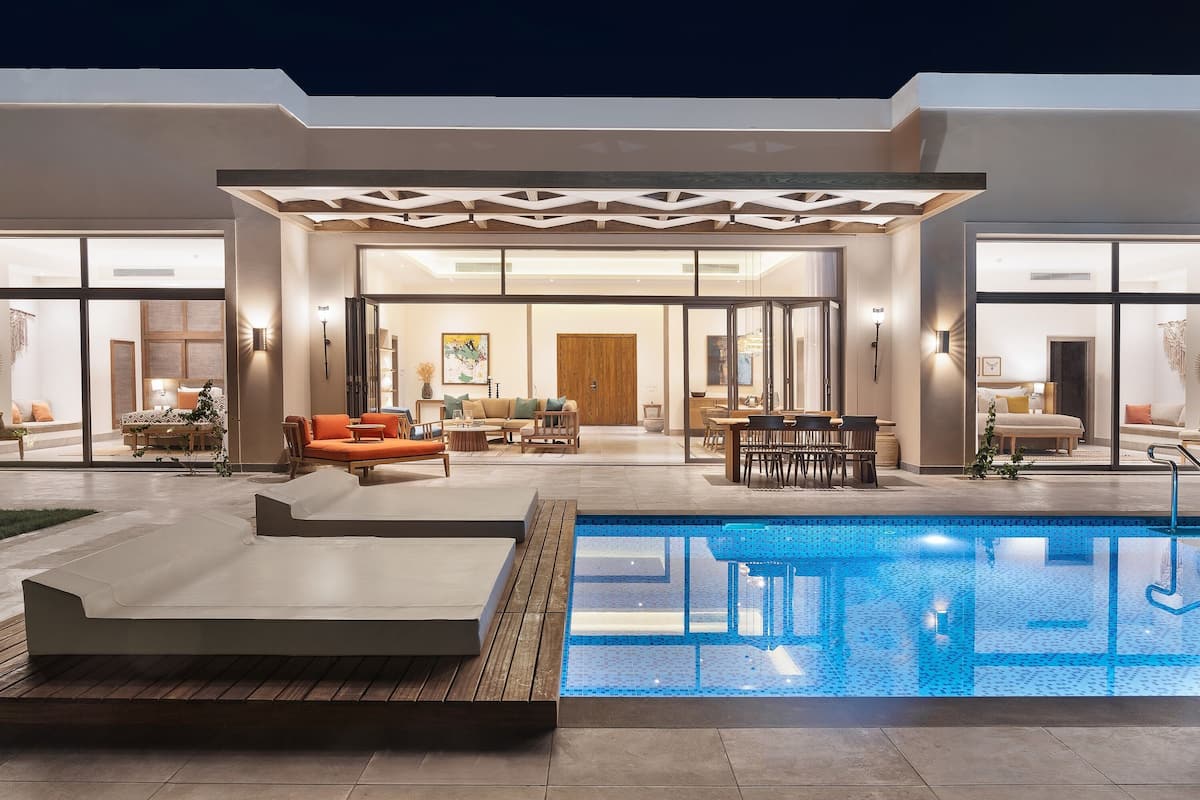 Uma casa moderna com piscina, área de estar externa e interior bem iluminado.