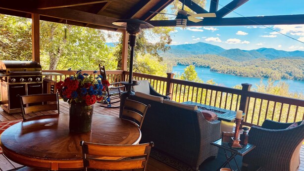 A wooden deck with a round table, chairs, and a grill. - Bear's Mountaintop Views 3 Bedroom Chalet by RedAwning (Robbinsville)
