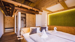 Une pièce en bois avec deux lits, un banc et un mur vert.