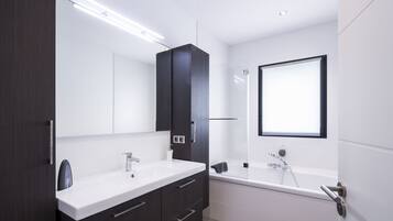 Tina con regadera, toallas, jabón, papel de baño