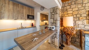 Eine moderne Küche mit Holzausstattung, einer Steinwand und einer rustikalen Lampe.