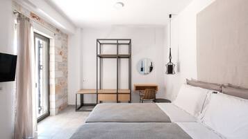 Una camera da letto moderna con un letto, una scrivania e una TV.