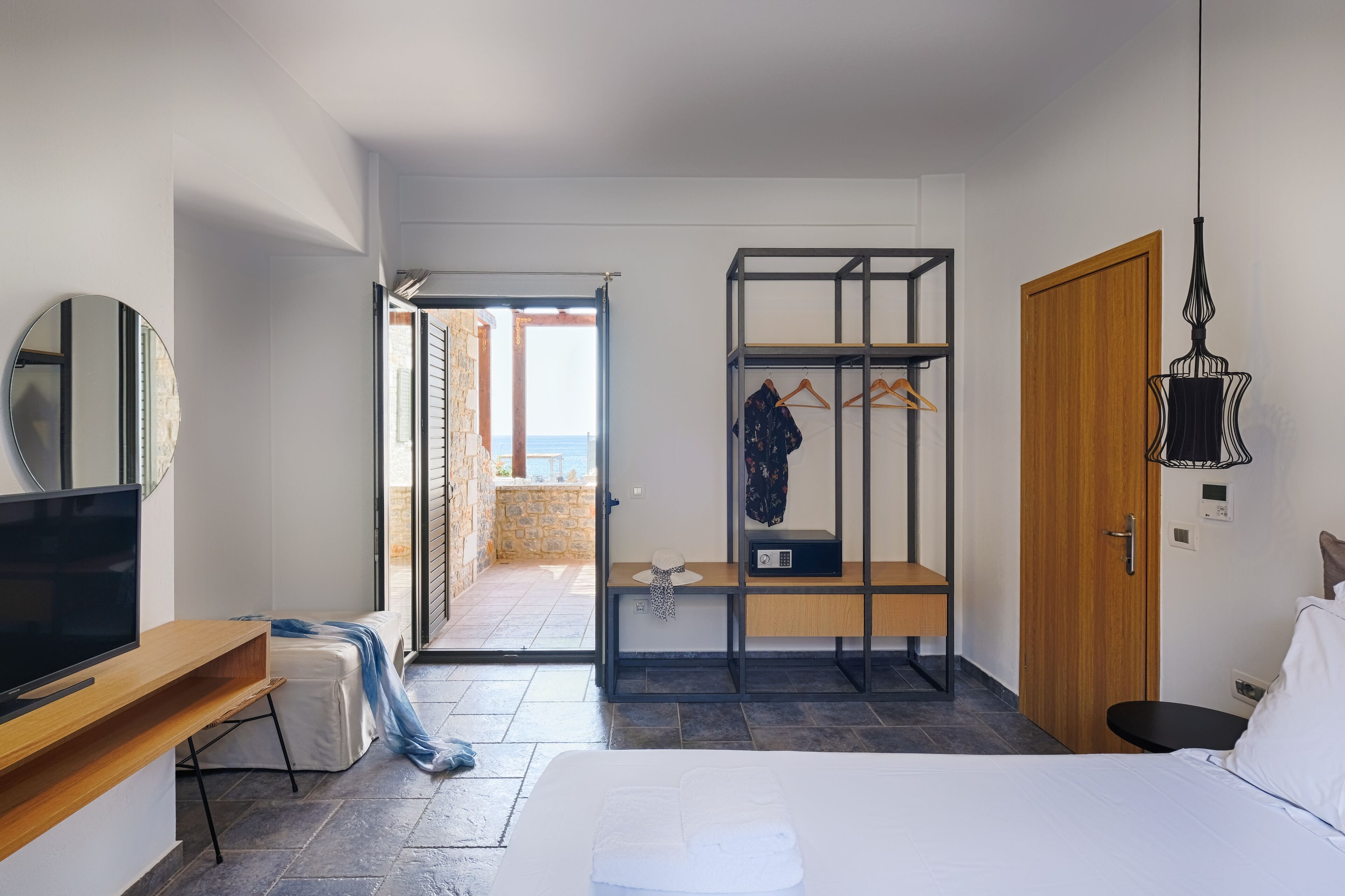 A bedroom with a bed, a TV, a wardrobe, and a desk.