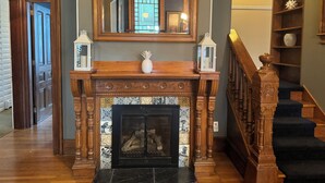 A grand hallway with a wooden fireplace, a large mirror, and a staircase. - Amazing location. Jackson St with pool.  Featured on #Staycation.  (Cape May)