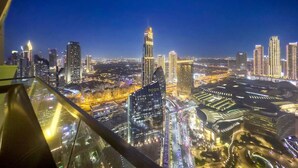 A nighttime cityscape with illuminated skyscrapers and a view of the urban landscape. - FIRST CLASS | 3BR | Burj Khalifa & Fountain view (Downtown)