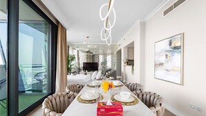 A modern dining area with a large table set for six, a view of the balcony, and a contemporary interior design. - FIRST CLASS | 3BR | Burj Khalifa & Fountain view (Downtown)