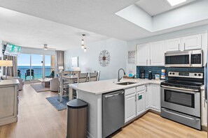 Una cucina moderna con lavastoviglie, forno e microonde, una zona pranzo con vista e un balcone panoramico.