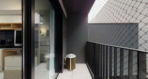 Eine moderne Küche mit weißen Schränken und einer Glastür zum Balkon.